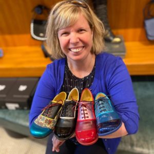 Darby holding 4 different pairs of John Fluevog "Darby" Shoes Picture